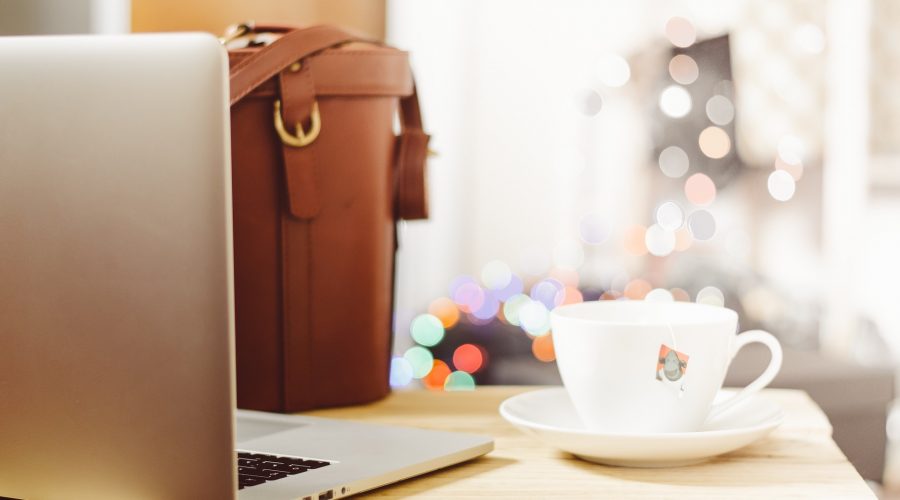 coffee mug, laptop and brown bag